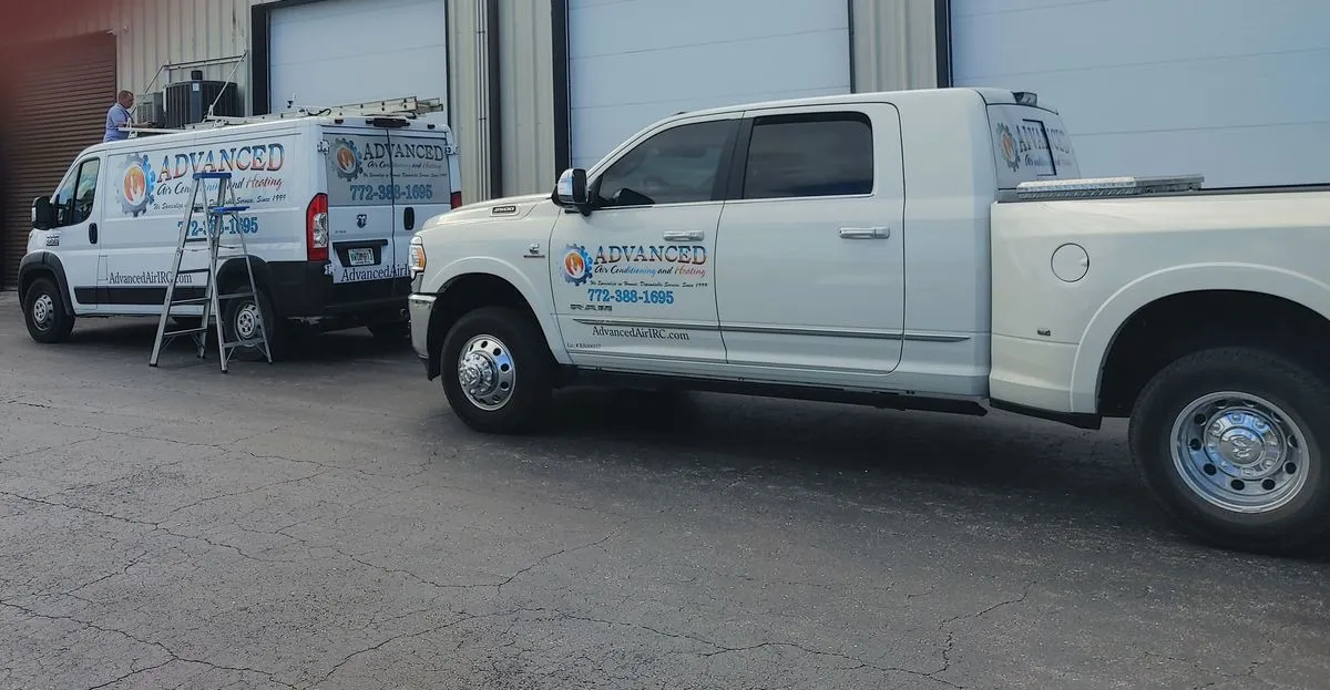 Two white service trucks with company logos