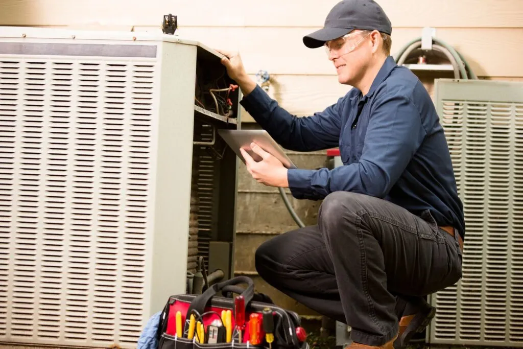 HVAC technician inspecting outdoor air conditioning unit