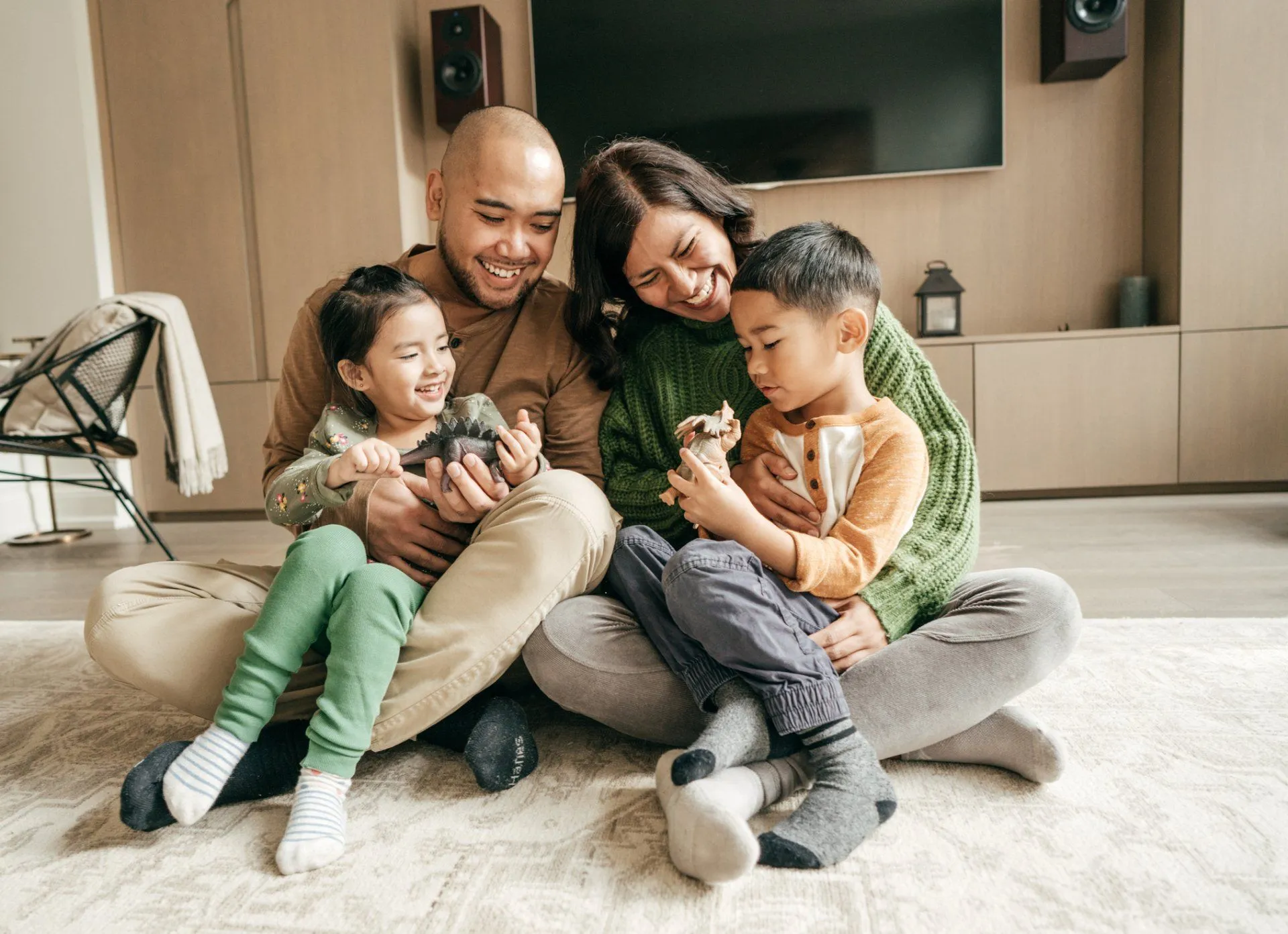 Family sitting on floor holding small pets