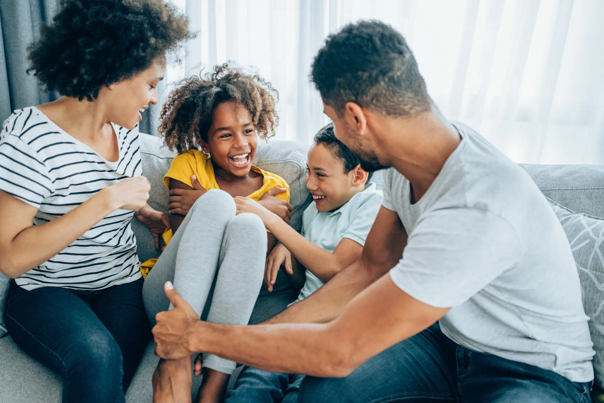 Smiling family laughing on couch